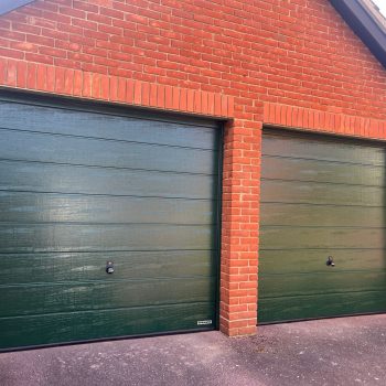 Matching single and double garage door in dark green